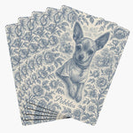 Five playing cards fanned face down, each back printed with a blue-on-cream toile engraving of a chihuahua framed by roses, with the name Pebbles below.