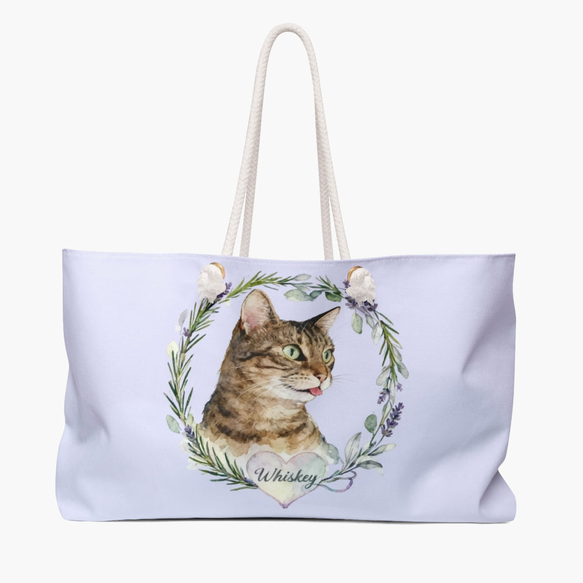 Pale lilac weekender bag printed with a rosemary and lavender wreath around a brown tabby cat, with "Whiskey" in script on a heart.