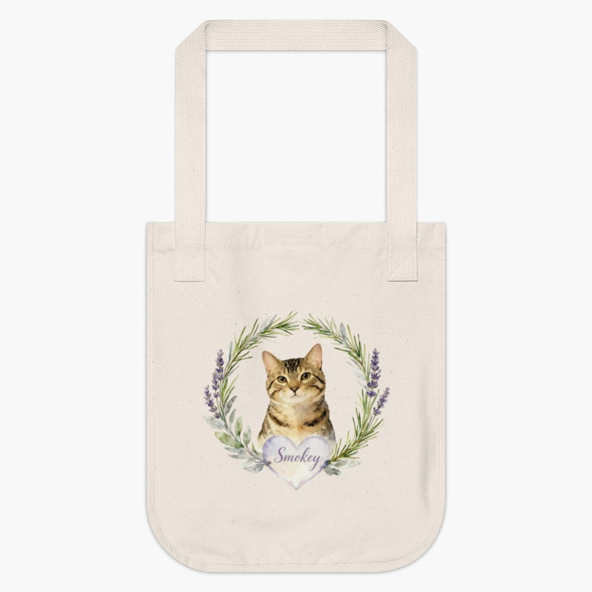 Natural cotton tote bag printed with a rosemary and lavender wreath around a brown tabby cat, with "Smokey" in script on a heart.