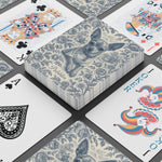 A stacked deck showing the blue chihuahua toile back named Pebbles, ringed by standard playing faces: two kings, an ornate ace of spades and a joker.