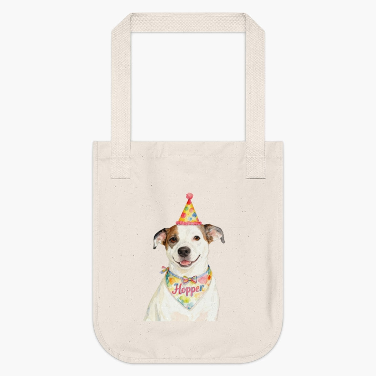 Natural cotton tote bag printed with a watercolor white and tan dog in a polka-dot party hat, wearing a bandana that reads "Hopper".