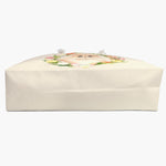 The cream tulip-wreath weekender bag laid on its side, showing the flat base and wide gusset, with the printed design just over the top edge.