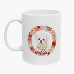 White Maltese in a patterned bandana inside a wreath of roses and hearts on a white mug, with the name Holiday in red script.