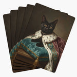 Five cards fanned face down, each back a painted portrait of a black cat wrapped in an ermine-trimmed pink robe on a teal cushion.