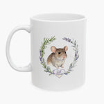 Watercolor portrait of a brown pet mouse inside a rosemary and lavender wreath on a white mug, with the name Joel Mouse on a heart below.
