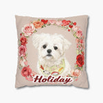 Watercolor white Maltese wearing a patterned bib inside a wreath of roses and hearts on a beige pillow, name "Holiday" in red script.