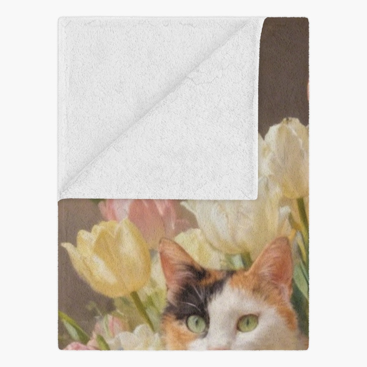 Folded corner of the blanket showing its plain white fleece backing, with the calico cat and tulip painting on the printed side.