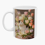Oil-painting style print of a calico cat sitting among pastel tulips, wrapped around the 11 oz white mug.