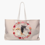 Blush weekender bag printed with a wreath of roses and hearts framing three cats together: a ginger, a gray and a pale cream kitten.