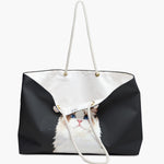 The charcoal gray weekender bag standing open, its white cotton lining showing, with the watercolor ragdoll cat portrait below.