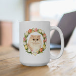 The larger mug on a wooden desk in front of a laptop, showing the cream Persian cat framed by a watercolor tulip wreath.