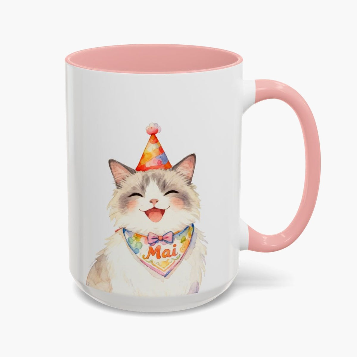 Watercolor fluffy cream cat laughing in a party hat on the taller 15 oz mug with a pink handle, the name Mai on its bandana.