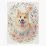Off-white fleece blanket printed with a smiling corgi inside a pastel wreath of pink roses, daisies and lavender.