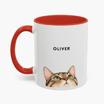 Watercolor tabby cat peeking up over the bottom edge of a white 11 oz mug with a red handle and inner glaze, name "OLIVER" above.