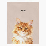 Watercolor portrait of a long-haired ginger cat printed on a dusty pink fleece blanket, with the name "MILO" in capitals above.