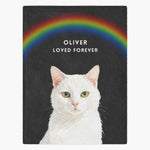 Watercolor white cat under a painted rainbow on a charcoal gray fleece blanket, with "OLIVER" and "LOVED FOREVER" below the arc.