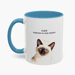 Watercolor Siamese cat wearing a gold halo on a white 11 oz mug with a light blue handle and inner glaze, lettered "CLEO" and "FOREVER IN OUR HEARTS".