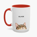 Watercolor tabby cat peeking up over the bottom edge of a taller white 15 oz mug with a red handle and inner glaze, name "OLIVER" above.